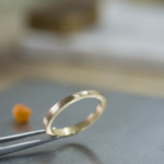 オーダーメイドマリッジリングの制作風景　ジュエリーのアトリエ　シャンパンゴールドのリング　奥に見える屋久島の貝殻　屋久島でつくる結婚指輪