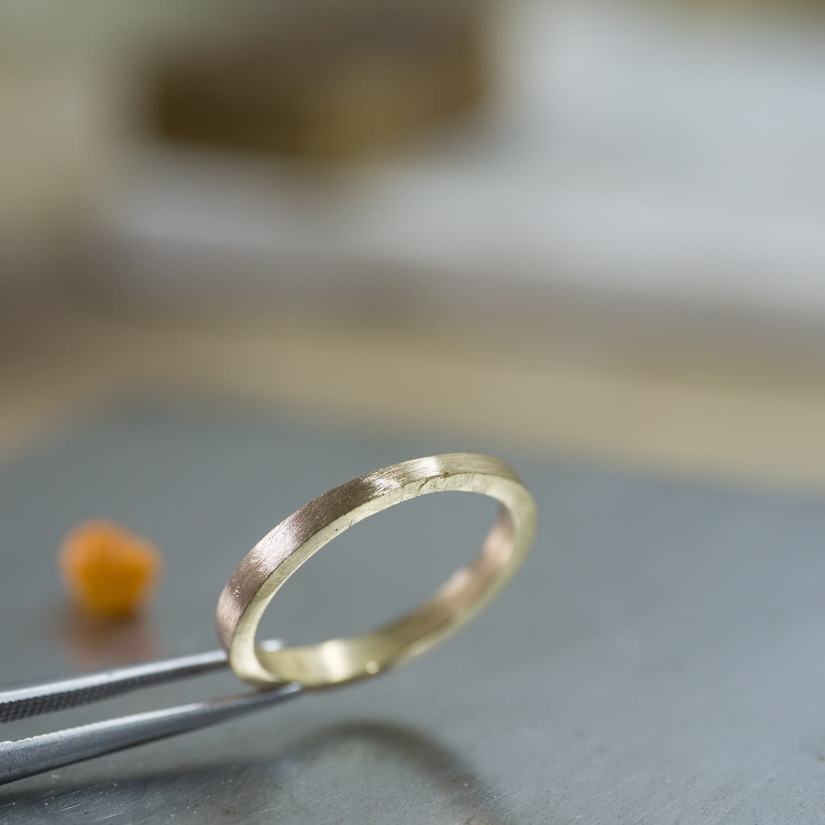 角度２　オーダーメイドマリッジリングの制作風景　ジュエリーのアトリエ　シャンパンゴールドのリング　奥に見える屋久島の貝殻　屋久島でつくる結婚指輪