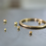 金の粒とリング　オーダーメイドマリッジリングの制作風景　ジュエリーのアトリエ　作業場に指輪　ゴールド　屋久島で作る結婚指輪