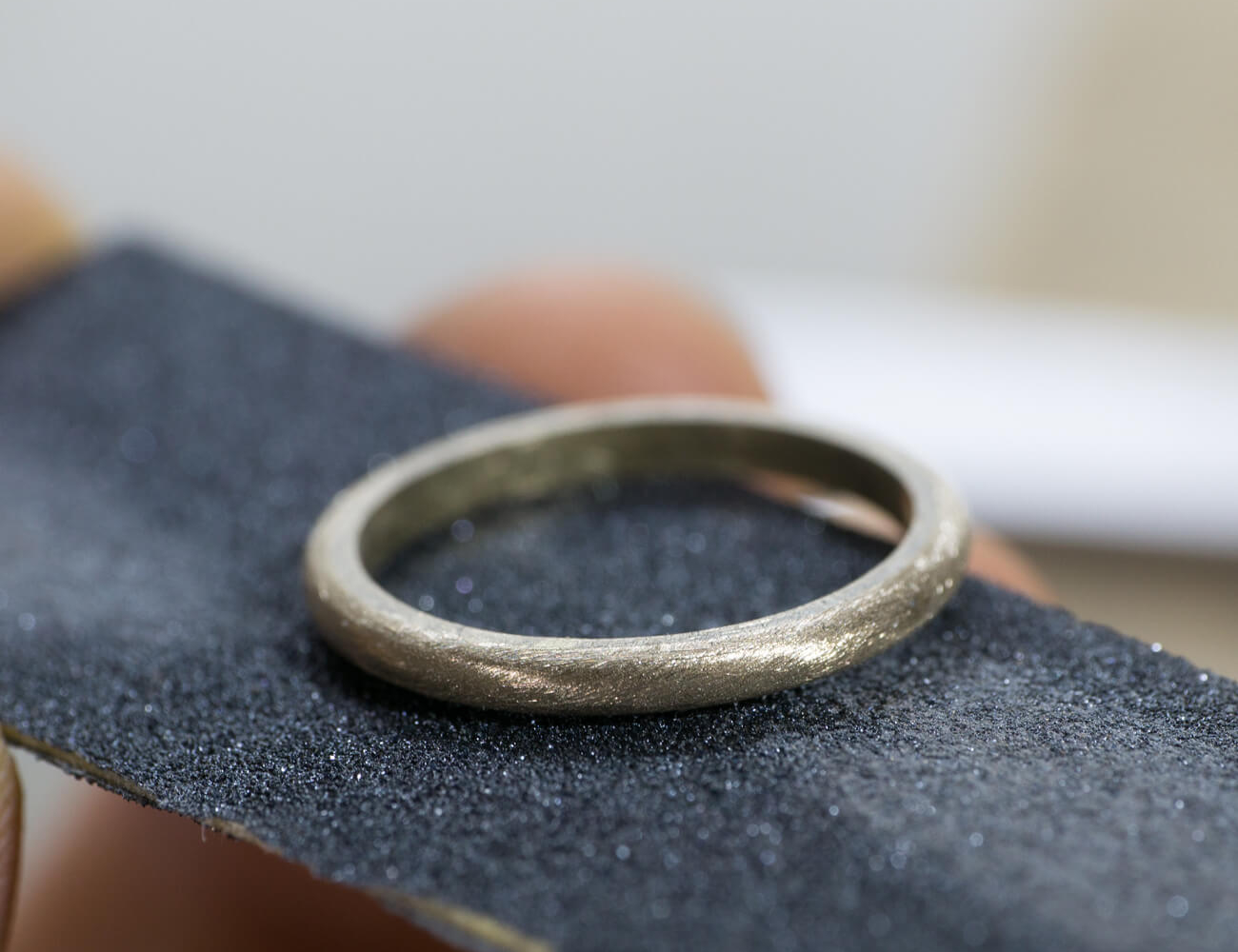 オーダーメイドマリッジリングの制作風景　ジュエリーのアトリエ　紙やすりと指輪　ゴールド　屋久島で作る結婚指輪