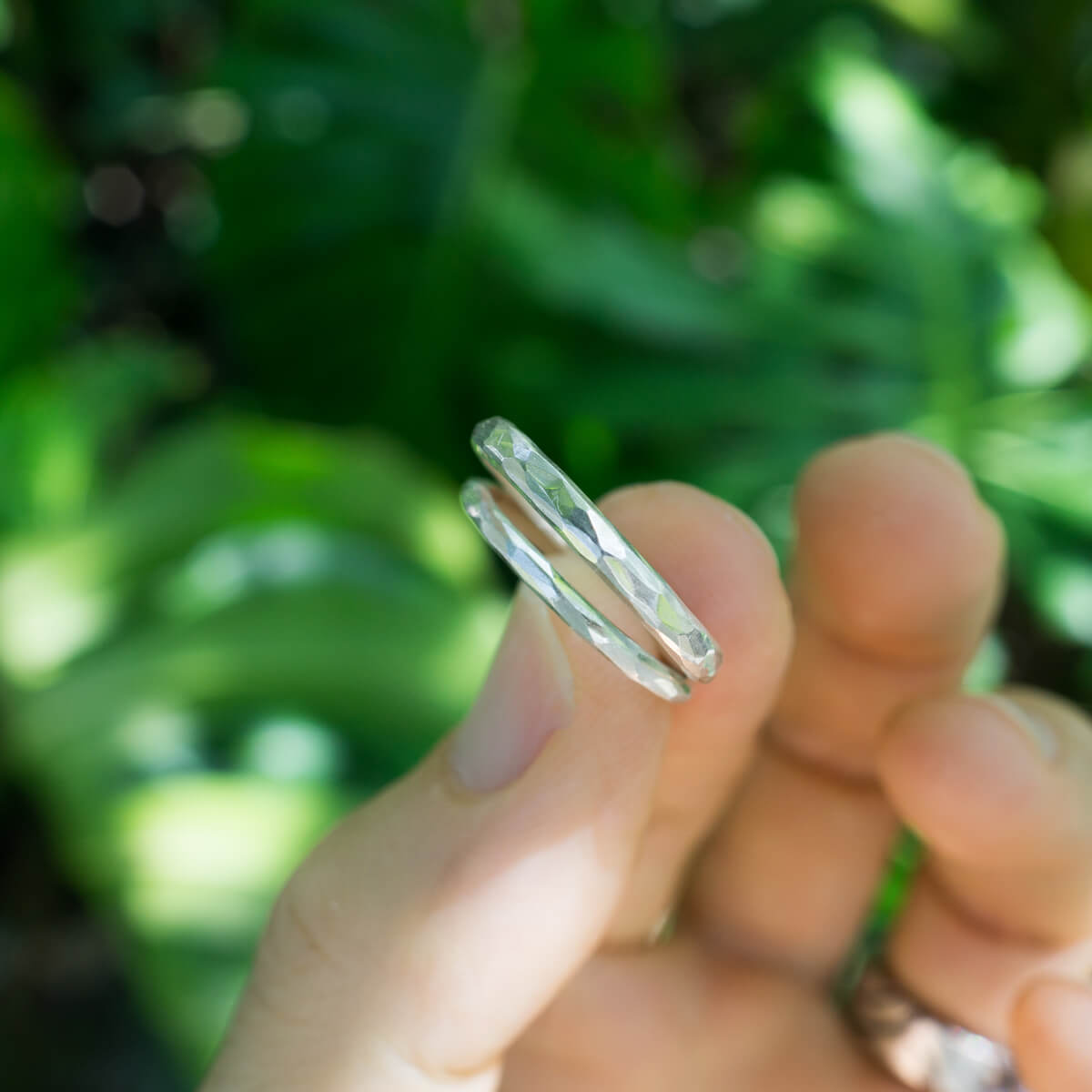 　結婚指輪のサンプルリング　手に持って　シルバー　屋久島の緑バック　屋久島でつくる結婚指輪