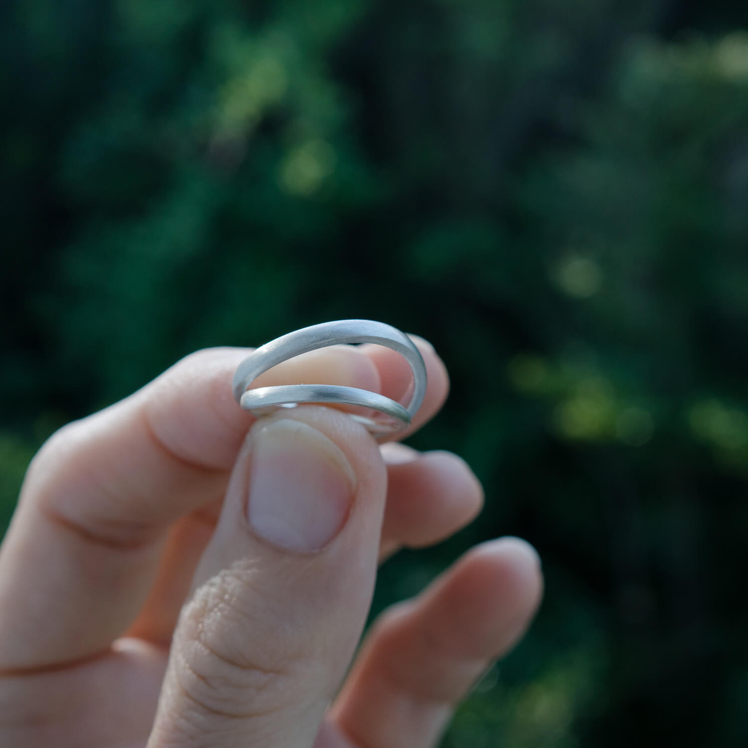 屋久島の緑バック　シルバーリングを手に　屋久島でつくる結婚指輪　