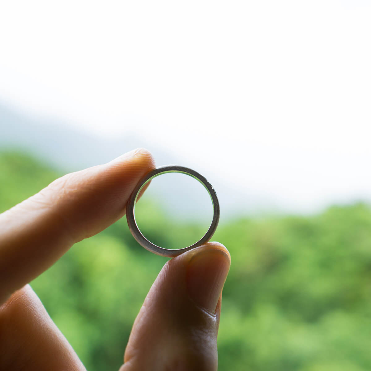 オーダーメイドマリッジリング　手に持って　奥に屋久島の山々　シルバー　屋久島でつくる結婚指輪