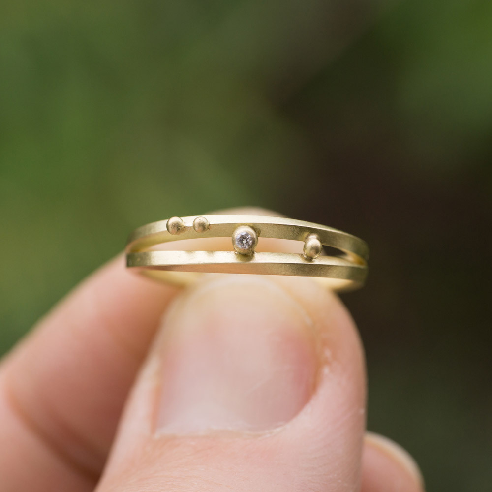 オーダーメイドの結婚指輪　屋久島の緑バック　手に持って３　ゴールド、ダイヤモンド