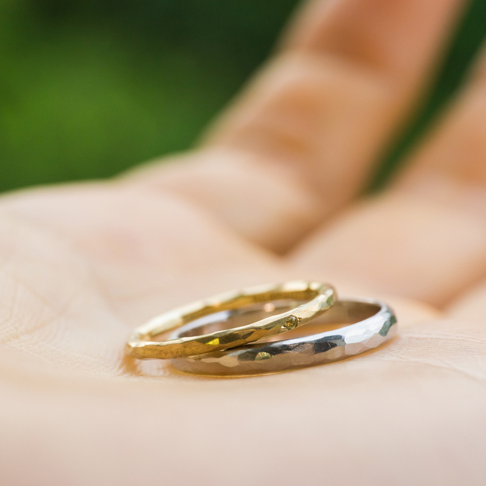 屋久島でつくる結婚指輪　手に持って　屋久島の緑バック　ゴールド、プラチナ、ダイヤモンド